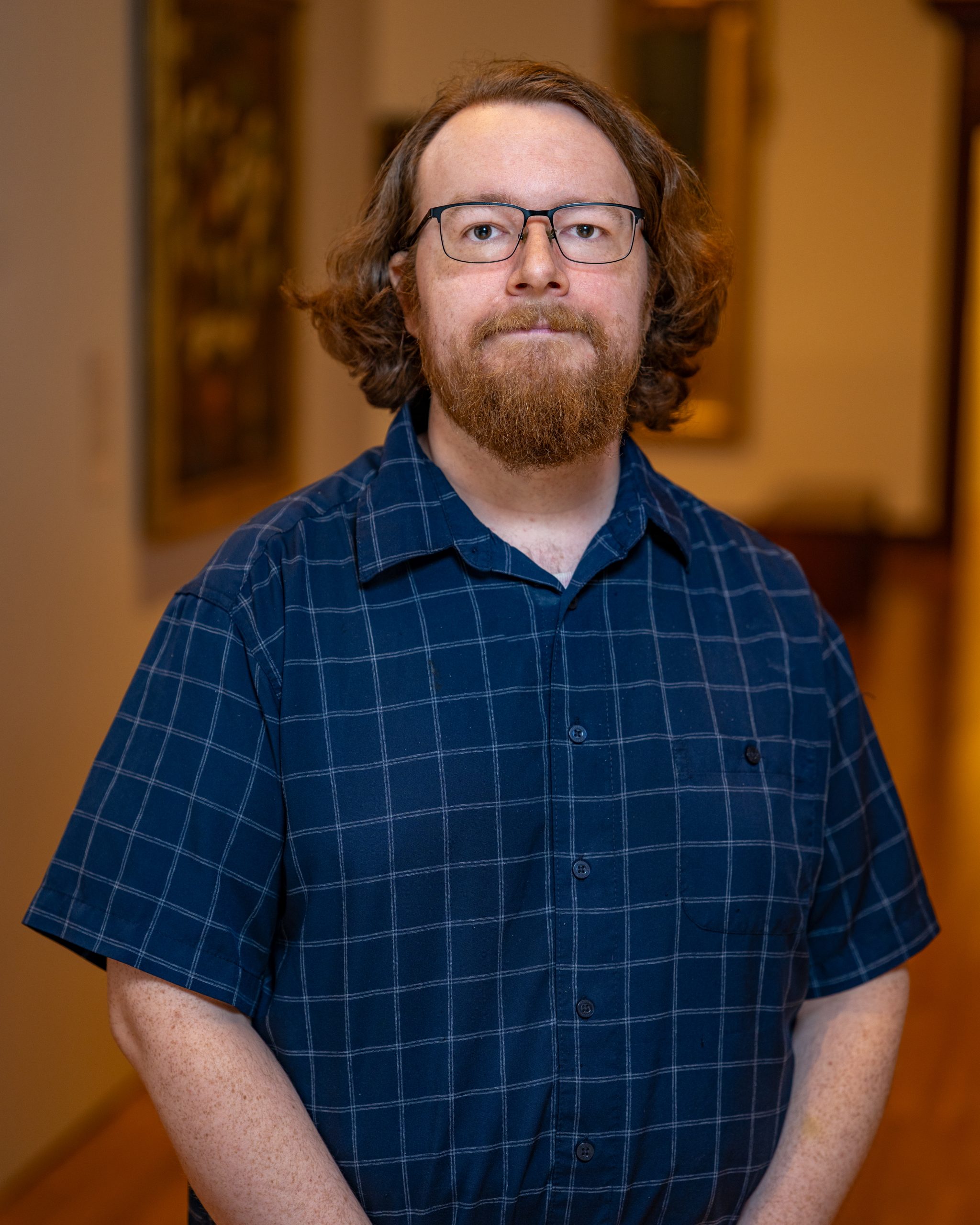 Kevin Gesseck in a blue shirt with check print and glasses