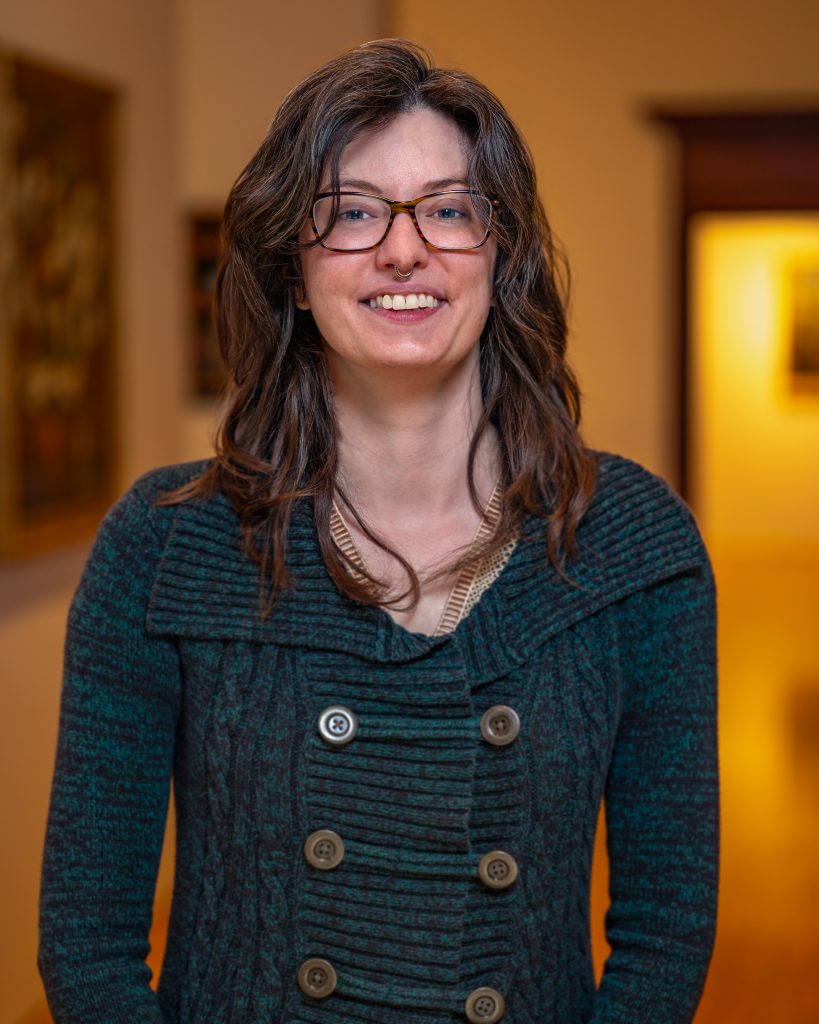 Mariah Ennis with glasses and a green sweater with buttons