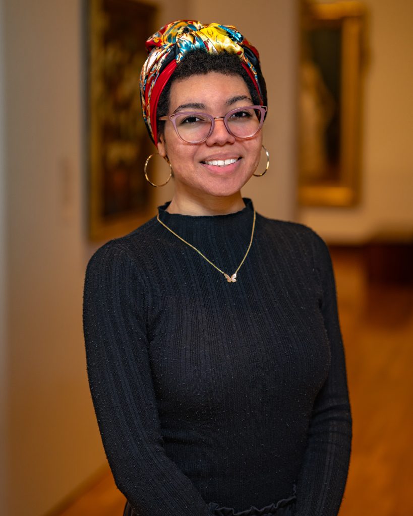 Nahndi Ali in a black shirt with glasses and colorful scarf