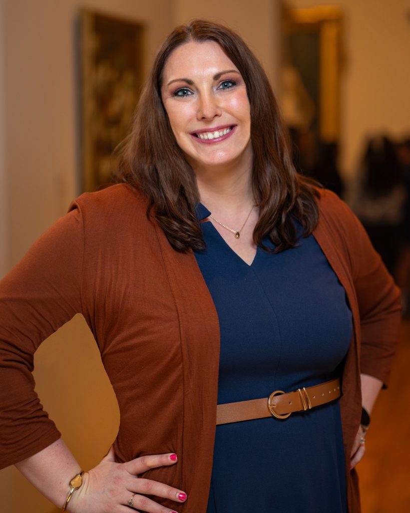 Stephanie Harris in blue dress with brown belt and brown sweater