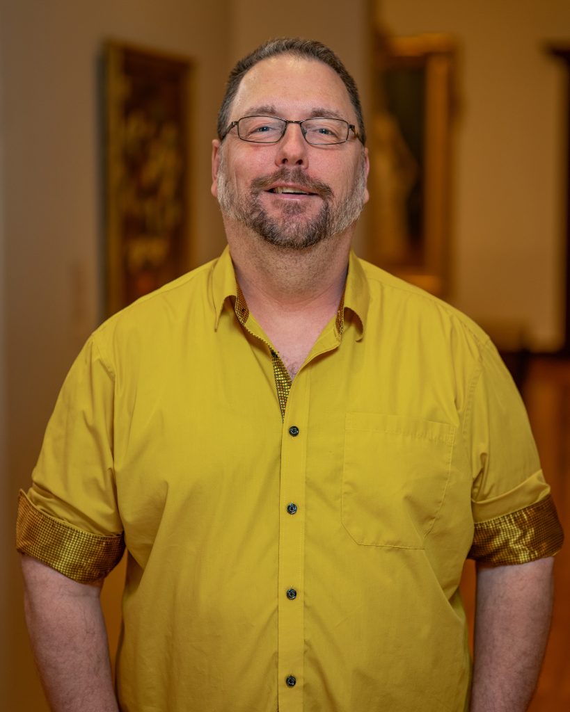 Wayne Eldred in yellow shirt and glasses
